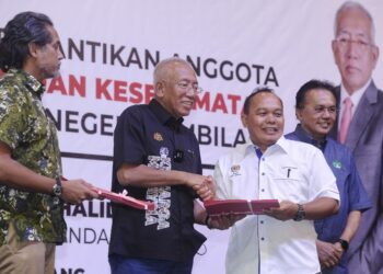 MAHDZIR Khalid diiringi Khairy menyampaikan watikah pelantikan kepada seorang ahli JPKKP Negeri Sembilan di Seremban hari ini.-UTUSAN/MOHD SHAHJEHAN MAAMIN.