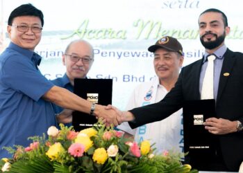 Usman Ahmed (kanan) bertukar dokumen perjanjian bersama Fredian Gan sambil disaksikan oleh Hajiji Noor (dua kanan) dan Yong Teck Lee (dua kiri) di Pelabuhan POIC Sabah di Lahad Datu semalam.