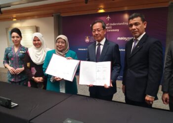 ROZIAH Mohd. Janor bertukar dokumen bersama Izham Ismail dalam majlis Menandatangani Perjanjian Persefahaman (MoU) antara MAB dan UiTM di UiTM, Shah Alam, Selangor, semalam.