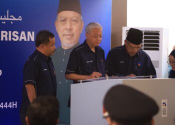 AHMAD Yakob (kanan) melihat Ismail Sabri Yaakob (tengah) menurunkan tanda tangan sebagai gimik perasmian Laman Warisan Kampung Laut, Tumpat, Kelantan hari ini.UTUSAN/KAMARUL BISMI KAMARULZAMAN