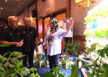 RONALD Kiandee (kiri) dan Ketua Pengarah Jabatan Pertanian, Datuk Zahimi Hassan mendengar penerangan ketika melihat ruang pameran pada Simposium Biosekuriti Tumbuhan Tahun 2022 yang diadakan di Seremban hari ini. - UTUSAN/BADRUL HAFIZAN MAT ISA