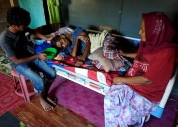 MOHD. Shahruddin Hazmah menguruskan abangnya yang terlantar sakit di Kampung Kedai Lama Rantau Panjang, Kelantan hari ini.