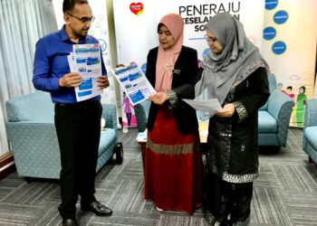 NORA Yaacob (tengah) bersama pegawainya menunjukkan maklumat mengenai caruman pekerja domestik di pejabat Perkeso, Kota Bharu, Kelantan. - UTUSAN/ROSLIZA MOHAMED