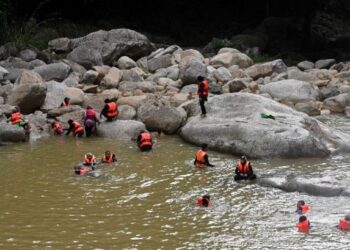 SEKUMPULAN pelancong mandi di dalam air yang keruh di kawasan Air Terjun Sungai Lasir, Tasik Kenyir, Hulu Terengganu, baru-baru ini. - UTUSAN/PUQTRA HAIRRY ROSLI