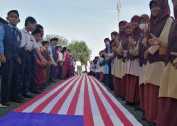 SEBAHAGIAN warga SK Kampung Raja, Pasir Puteh, Kelantan berpadu tenaga menjayakan perarakan Jalur Gemilang sepanjang 17 meter sempena penutup sambutan Bulan Kemerdekaan semalam. - UTUSAN/TOREK SULONG