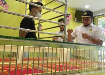 MOHD. Faizuddin Che Mahmod (kanan) menunjukkan rekaan emas terbaharu di pejabat urusan Ko-Makmur di Kuantan, Pahang. - UTUSAN/ DIANA SURYA ABD WAHAB