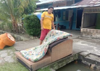 JOHAN Buning membersihkan rumahnya di Pekan Sri Gading selepas dibenarkan pulang dari PPS SMK Sri Gading, Batu Pahat.