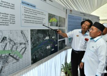 TUAN Ibrahim Tuan Man diberi penerangan mengenai Projek Pemuliharaan Muara Sungai Dungun selepas melancarkan projek tersebut di Dungun, Terengganu, hari ini. - UTUSAN/PUQTRA HAIRRY ROSLI