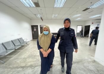 ANGGOTA polis (kanan) mengiringi tertuduh semasa menghadiri perbicaraan di Mahkamah Sesyen Kota Bharu, Kelantan hari ini.