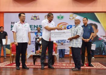 ABDUL RAZAK Abdul Rahman (empat dari kiri) menyampaikan replika cek kepada seorang penerima pada Majlis Konvensyen GAP Peringkat Risda Melaka di Kompleks Komuniti Desa (KKD) Telok Mas, Melaka.