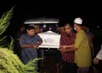 JENAZAH Bob Lokman dibawa turun dari van untuk disemadikan di Tanah Perkuburan Islam Pulau Hilir, Kubang Kerian, Kelantan malam tadi-UTUSAN/KAMARUL BISMI KAMARUZAMAN
