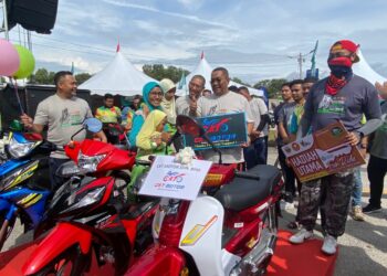 MUHAMMAD Sanusi Md. Nor (dua kanan) bersama Ahmad Faizal Azumu bergambar dengan para pemenang cabutan bertuah yang berjaya membawa pulang tiga buah motosikal sempena Karnival Sejahtera Prihatin Negara di Dataran Aman Jaya Mall, Sungai Petani hari ini.