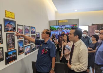 MAH Hang Soon (kiri) melihat gambar yang dipamerkan di galeri SMJK Tsung Wah di Kuala Kangsar hari ini.-UTUSAN/ MOHAMAD HAFIZI MOHD SAID.