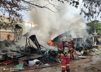ANGGOTA bomba melakukan kerja-kerja memadamkan kebakaran sebuah rumah di Jalan Tanjung Labuh, Batu Pahat.