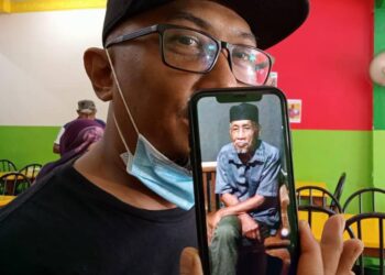 NOOR AZALI menunjukkan gambar ayahnya yang dilaporkan hilang sejak Isnin lalu.