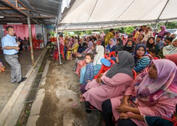 IKMAL Hisham Abdul Aziz (kiri) ketika beramah mesra dengan penduduk pada Program Bekwoh Kampung Pusat Daerah Mengundi (PDM) Perala di Tanah Merah, Kelantan.-UTUSAN/ROSALWANI CHE SOH