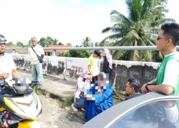 WANITA berkenaan (baju) berjaya ditenangkan semasa cuba di 
Jambatan Tendong, Pasir Mas, Kelantan.-UTUSAN/FACEBOOK