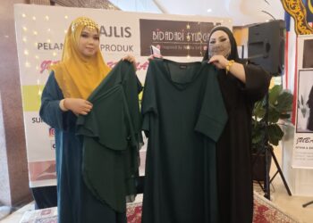 Noraini kamaruddin (kanan)  menunjukkan produk keluaran syarikatnya