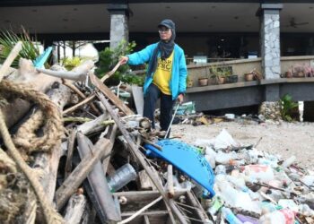 ROSNANI Nazri mengutip sampah di lokasi pelancongan sekitar Perlis termasuk di sekitar masjid terapung, Kuala Perlis, semalam. – UTUSAN/IZLIZAN OTHMAN