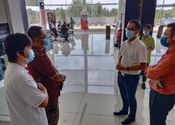 DENNIS Lee Han Lim (dua dari kanan) berbincang dengan Tay Han Sin (dua dari kiri) selepas mengadakan pertemuan dengan wakil sebuah pusat servis kenderaan di Ayer Keroh, Melaka. - UTUSAN/MUHAMMAD SHAHIZAM TAZALI