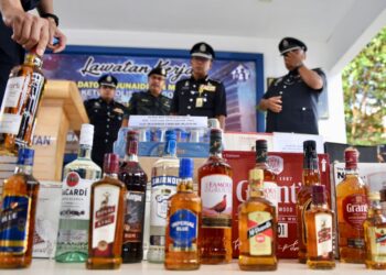 KETUA Polis Selangor, Datuk Arjunaidi Mohamed (tengah) melihat barangan rampasan minuman keras pelbagai jenama tanpa cukai bernilai kira-kira RM2.1 juta dalam serbuan di sebuah premis sewaktu sidang media di Ibu Pejabat Polis Daerah Klang Selatan, Selangor pada hari ini.-UTUSAN/ZULFADHLI ZAKI