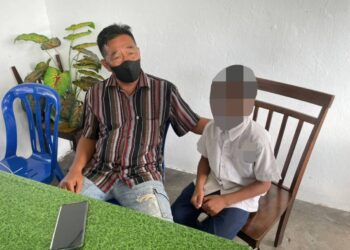 AHMAD Ismail (kiri) bersama anaknya ketika di temubual pemberita di bandar Pasir Puteh, Kelantan, hari ini.-UTUSAN/TOREK SULONG