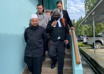 EBIT Lew (kiri) bersama peguamnya Ram Singh (kanan) semasa keluar dari Mahkamah Majistret Tenom hari ini