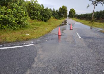 Air pasang besar setinggi 5.4 meter menaiki kawasan jalan raya di sepanjang Pantai Kelanang pagi ini.-UTUSAN/ABDUL RAZAK IDRIS