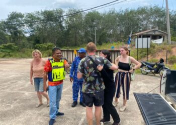 MAZLAN Hassan (depan, kiri) mengiringi keluarga pelancong warga British yang baharu ditemui di Kampung Pagi, Ulu Tembeling di Jerantut, Pahang. IHSAN IPD JERANTUT