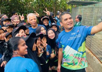 RADZI Jidin (kanan) meluangkan masa bergambar bersama murid yang menyertai Program Eksplorasi Alam Lestari Siri Ketiga di Pusat Konservasi Hidupan Liar (PKHL) di Sungkai, Tanjung Malim hari ini. - UTUSAN/ASLIZA MUSA