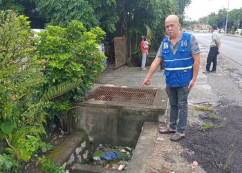 LIEN Su Lim menunjukkan longkang tersumbat menetap di 
Kampung Batu Dua, Jalan Ayer Hitam, Dengkil, Selangor.