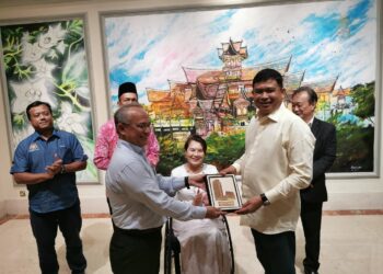 MOHAMAD ALI Mohamad (kanan) menyampaikan cenderahati daripada Parlimen Malaysia kepada wakil Hotel La Crista, Banda Hilir, Melaka selepas mempengerusikan mesyuarat Jawatankuasa Pilihan Khas Kesejahteraan Rakyat, Majlis Mesyuarat Dewan Negara. - UTUSAN/AMRAN MULUP