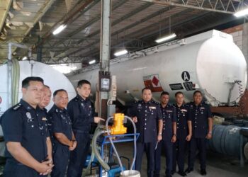 AHMAD ZAMRY MARINSAH (empat dari kanan) menunjukkan peralatan yang digunakan bagi aktiviti penyelewengan diesel bersubsidi di sebuah gudang kosong di Kampung Logah, Segamat.