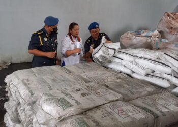 NORENA Jaafar (tengah) bersama dua anggota KPDNHEP memeriksa baja sebatian bersubsidi yang dirampas di sebuah gudang di Kawasan Perindustrian Bukit Rambai, Melaka. - UTUSAN/AMRAN MULUP