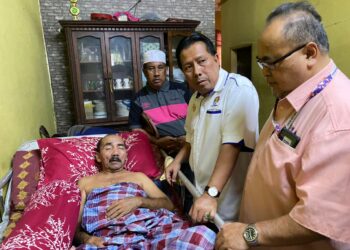 MOHD. Zin Ismail (kiri) yang terlantar selepas diserang angin ahmar sejak dua minggu lalu menerima kunjungan  Zulkepli di rumahnya di Kampung Kedai Lalat, Kota Bharu, Kelantan.UTUSAN/ROHANA MOHD.NAWI.