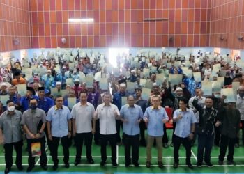 AZLAN MAN (depan, lima dari kanan) bersama penerima dokumen pemilikan tanah kerajaan negeri di Dewan Besar Felda Chuping, Padang Besar, Perlis hari ini. - UTUSAN/SYED AZLAN HIZAR