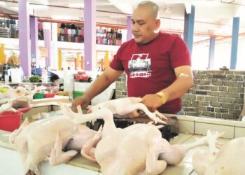 KHARIZAL Othman terpaksa menjual ayam dengan harga RM9.40 sekilogram di Pasar Besar Tasek Raja, Pasir Mas, Kelantan. – UTUSAN/ROHANA ISMAIL