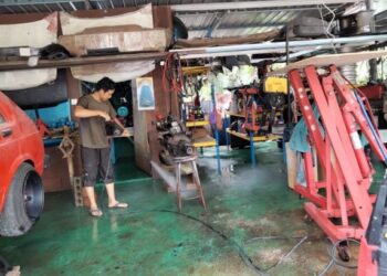 MOHD. FAKHRURAZI MASHARI membersihkan bengkel kenderaan yang ditenggelami banjir termenung di JK8, Jalan Keliling, Kampung Parit Lancang, Ayer Baloi, Pontian.