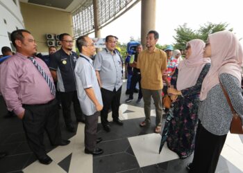 SHARIFUDIN Md. Shaarani (empat dari kiri) beramah mesra bersama ibu bapa dan pelajar baharu pada program Pendaftaran Pelajar Sarjana Muda Sesi Akademik 2022/2023 di USIM, Nilai, Seremban hari ini.-UTUSAN/ZAKKINA WATI AHMAD TARMIZI.