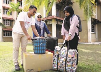 NUR Amalin Syaffah Saman (kanan) dibantu kakitangan Yayasan Raja Shamri membawa barang-barang  ke kolej kediaman di Kampus Gong Badak UniSZA, Kuala Nerus, Terengganu, semalam. – UTUSAN/KAMALIZA KAMARUDDIN
