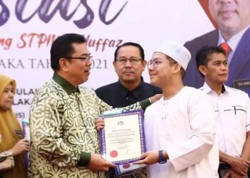 SULAIMAN Md. Ali (kiri) menyampaikan sijil kepada seorang hafiz pada Majlis Apresiasi Pelajar Cemerlang Sijil Tinggi Pelajaran Malaysia (STPM) dan Hafiz di Ayer Keroh, Melaka. - UTUSAN/MUHAMMAD SHAHIZAM TAZALI