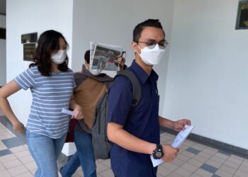 CHONG Hui Yee (kiri) keluar dari Mahkamah Sesyen, Ayer Keroh, Melaka selepas mengaku bersalah menjual kelengkapan komunikasi tidak diperakui. - UTUSAN/MUHAMMAD SHAHIZAM TAZALI