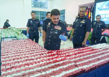 AZMI Abu Kassim memeriksa rampasan 213 kilogram syabu dan 33 kilogram erimin 5 bernilai RM10 juta di Ibu pejabat Polis Kontinjen Kuala Lumpur. - UTUSAN/SHIDDIEQIIN ZON