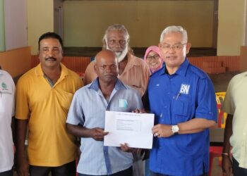NOH Omar (dua dari kanan) menyampaikan sumbangan kepada salah seorang penerima bantuan di Kuil Sri Mahariaman, Kuala Selangor, Selangor hari ini-UTUSAN/ ISKANDAR SHAH MOHAMED