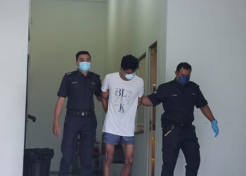 MUHAMAD Farhan Mat Sahid dibawa ke Mahkamah Majistret Kajang diiringi anggota polis bagi menghadapi pertuduhan menumbuk muka dan lengan adik perempuannya. -UTUSAN/AMIR KHALID