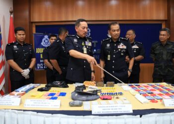 MUHAMAD Zaki Harun (tengah) menunjukkan dadah yang dirampas semasa membuat serbuan di Pasir Mas, Kelantan.-UTUSAN/KAMARUL BISMI KAMARUZAMAN