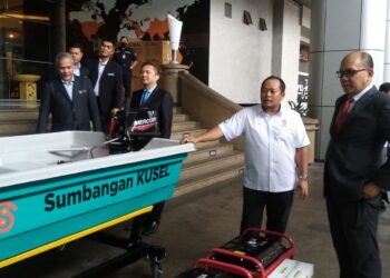 IZHAM Hashim (kanan) melihat sebuah bot yang disumbangkan oleh KUSEL di Bangunan SUK Selangor, Shah Alam, Selangor hari ini-UTUSAN/ MOHAMAD NAUFAL MOHAMAD IDRIS