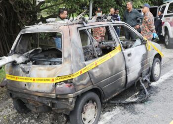 VIJAYA Rao (baju hitam) meninjau kebakaran kereta itu di lokasi kejadian hari ini.