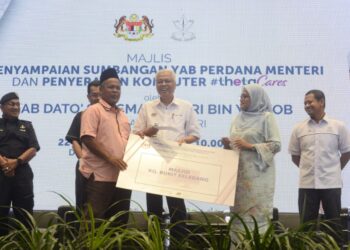 ISMAIL SABRI Yaakob (tengah) menyampaikan sumbangan kepada wakil penerima pada majlis penyampaian sumbangan Perdana Menteri dan penyerahan komputer #thetaCares di Dewan Konvensyen Majlis Daerah Bera di Bera, Pahang. - UTUSAN/SHAIKH AHMAD RAZIF