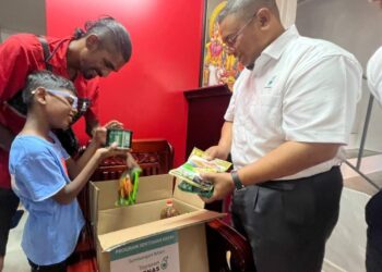 MOHD. ZAKI MAHAT menyampaikan bantuan kepada salah seorang penerima sempena sambutan Hari Deepavali.